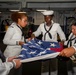 Sailors fold the flag aboard USS Carl Vinson