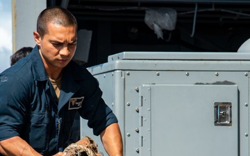 Sailor heaves line aboard USS Carl Vinson