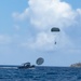 EOD sailors execute a water jump over Guam, landing in Apra Harbor