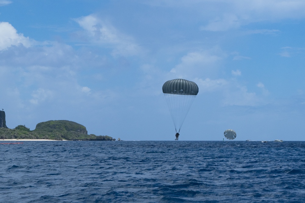 An EOD sailor executes a water jump from a C-2 aircraft into Apra Harbor, Guam