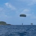 An EOD sailor executes a water jump from a C-2 aircraft into Apra Harbor, Guam