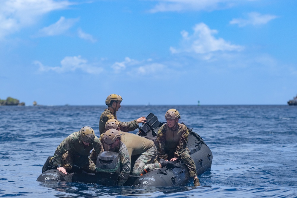 EOD sailors prepare a rubber water craft dropped during a static line jump in Apra Harbor, Guam.