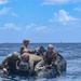 EOD sailors prepare a rubber water craft dropped during a static line jump in Apra Harbor, Guam.