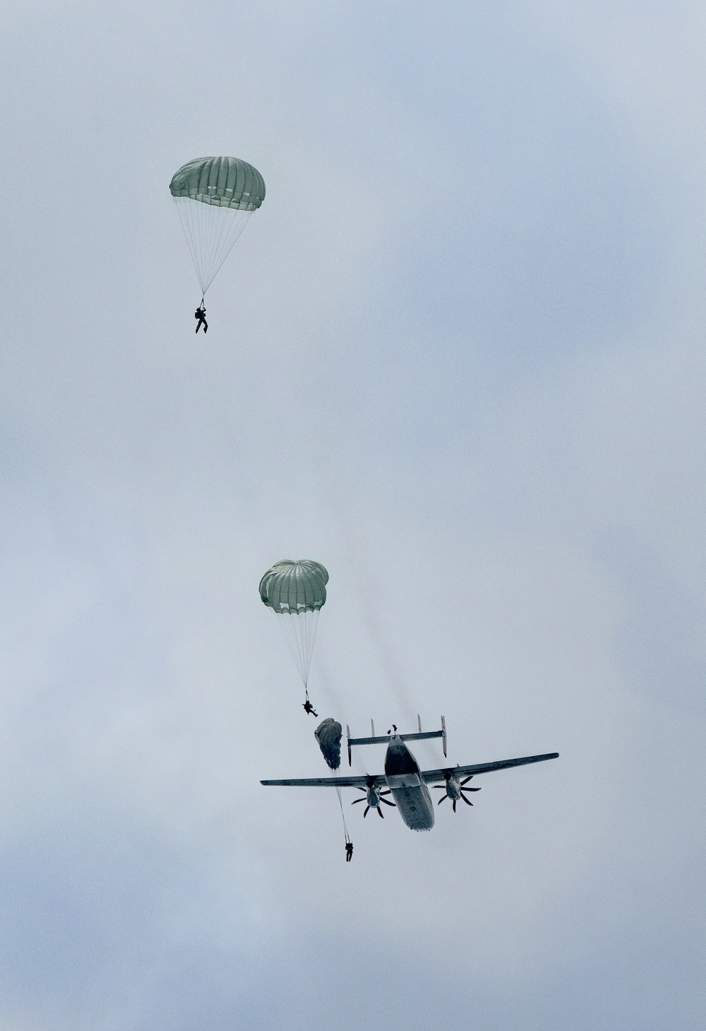 Sailors with EODMU5 jump out of a C-2 aircraft during a static line water jump over Guam