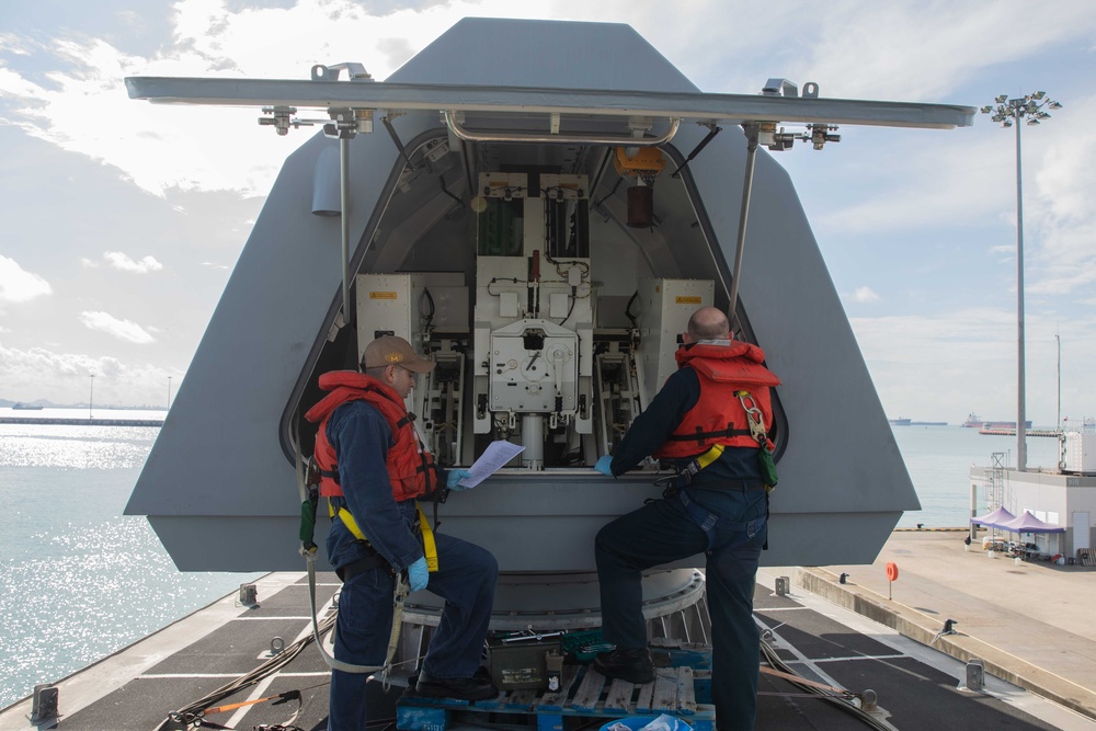 Sailors preform gun maintenance aboard USS Mobile