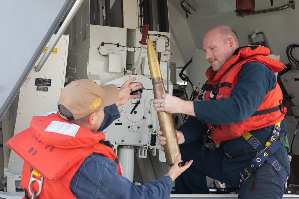 Sailors preform gun maintenance aboard USS Mobile