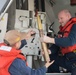 Sailors preform gun maintenance aboard USS Mobile