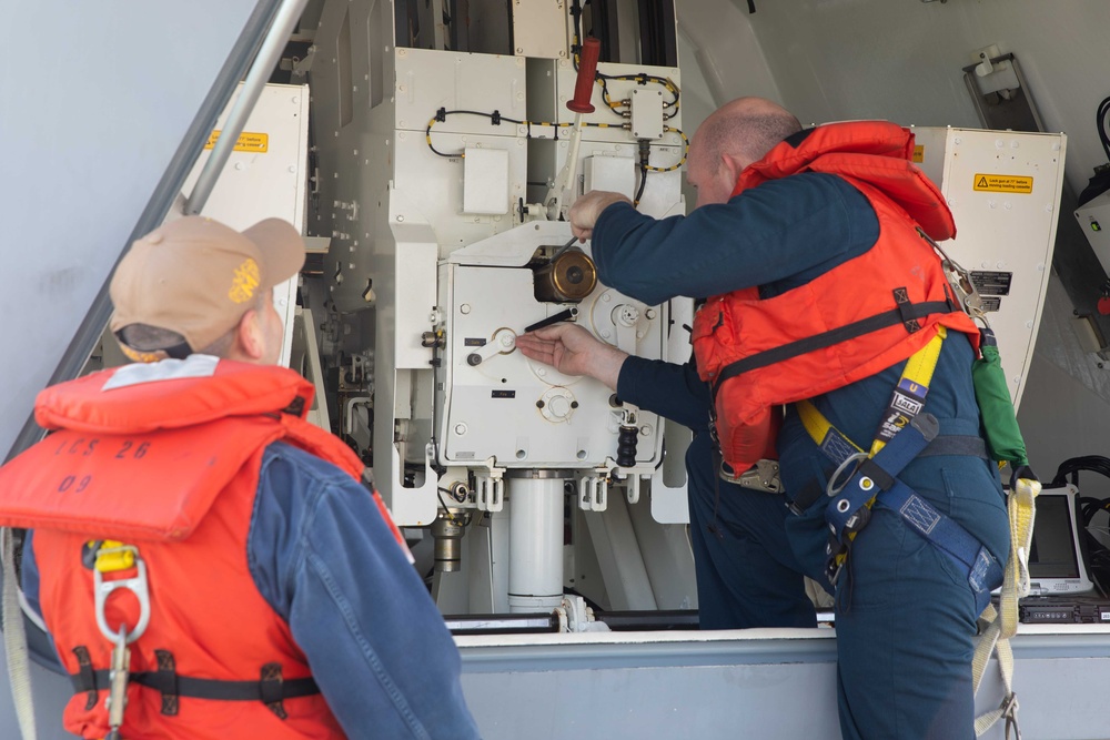 Sailors preform gun maintenance aboard USS Mobile