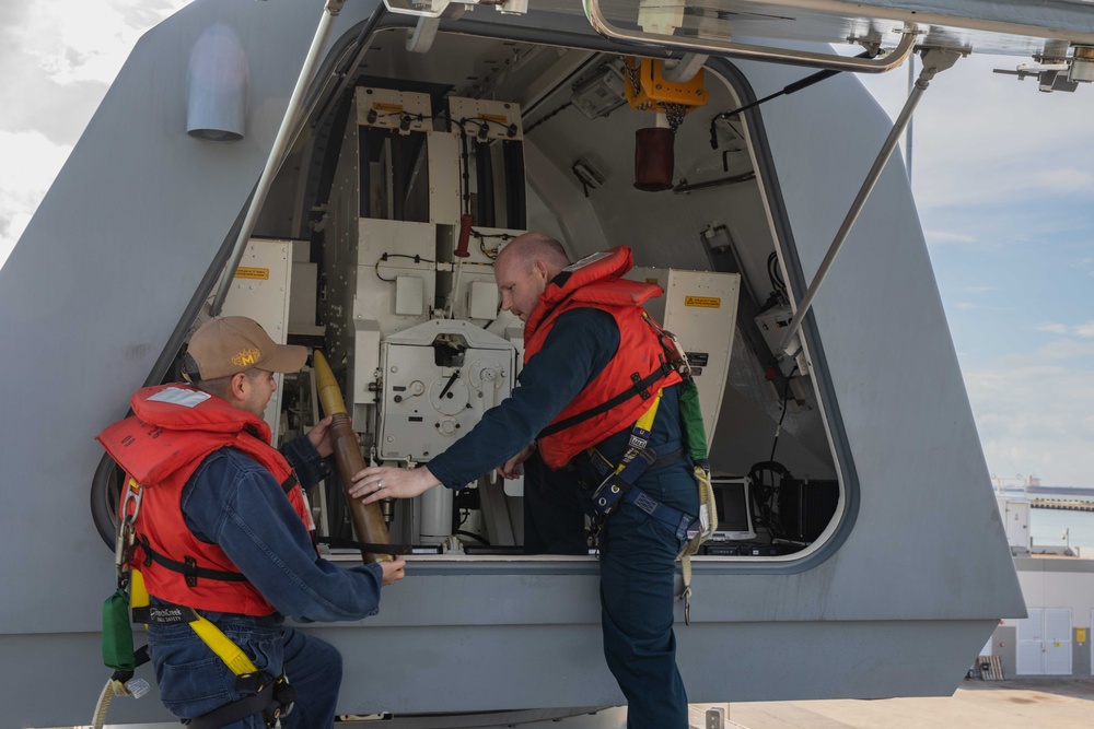 Sailors preform gun maintenance aboard USS Mobile