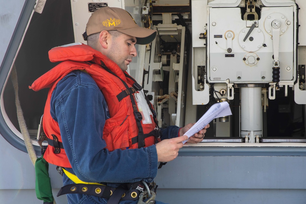 Sailors preform gun maintenance aboard USS Mobile