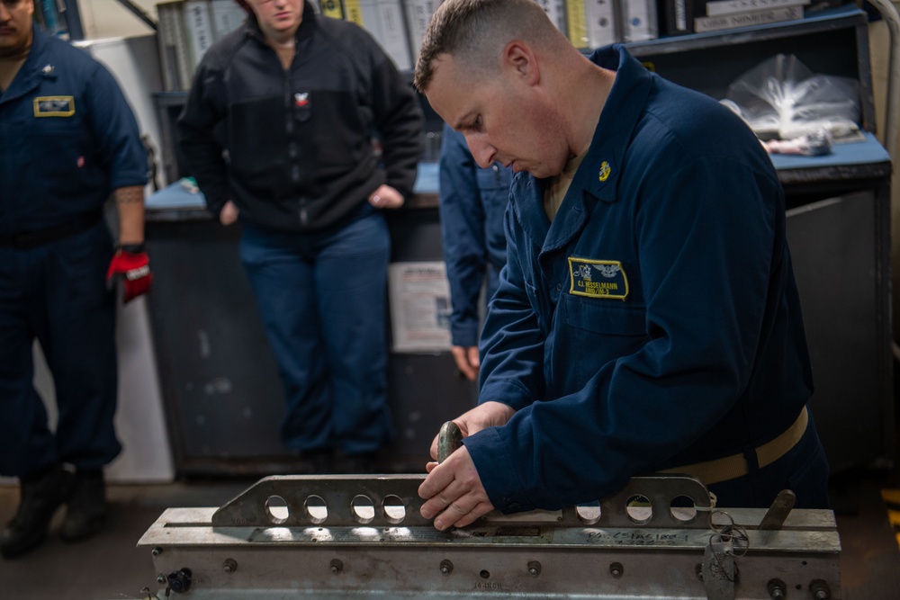 Sailors Prepare To Hoist An Ordnance Shell