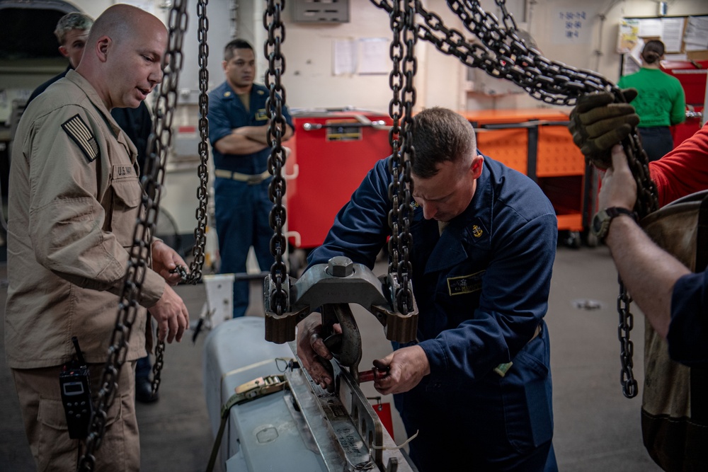 Sailors Prepare To Hoist An Ordnance Shell