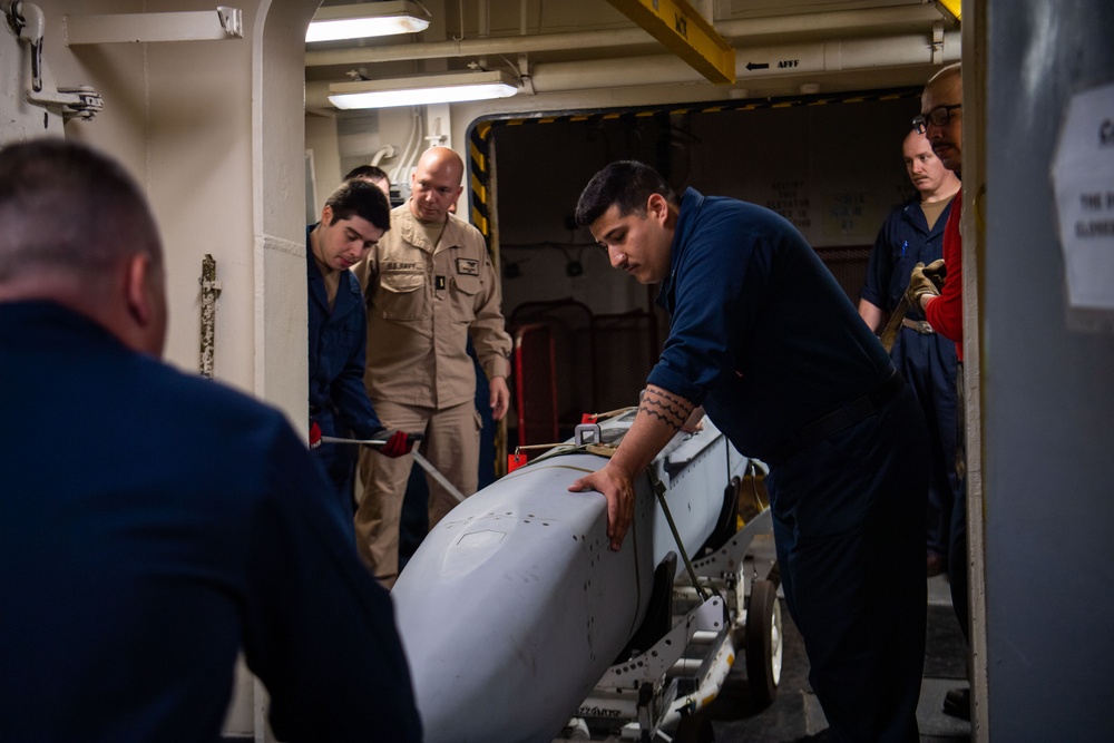 Sailors Move An Ordnance Shell