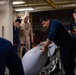 Sailors Move An Ordnance Shell