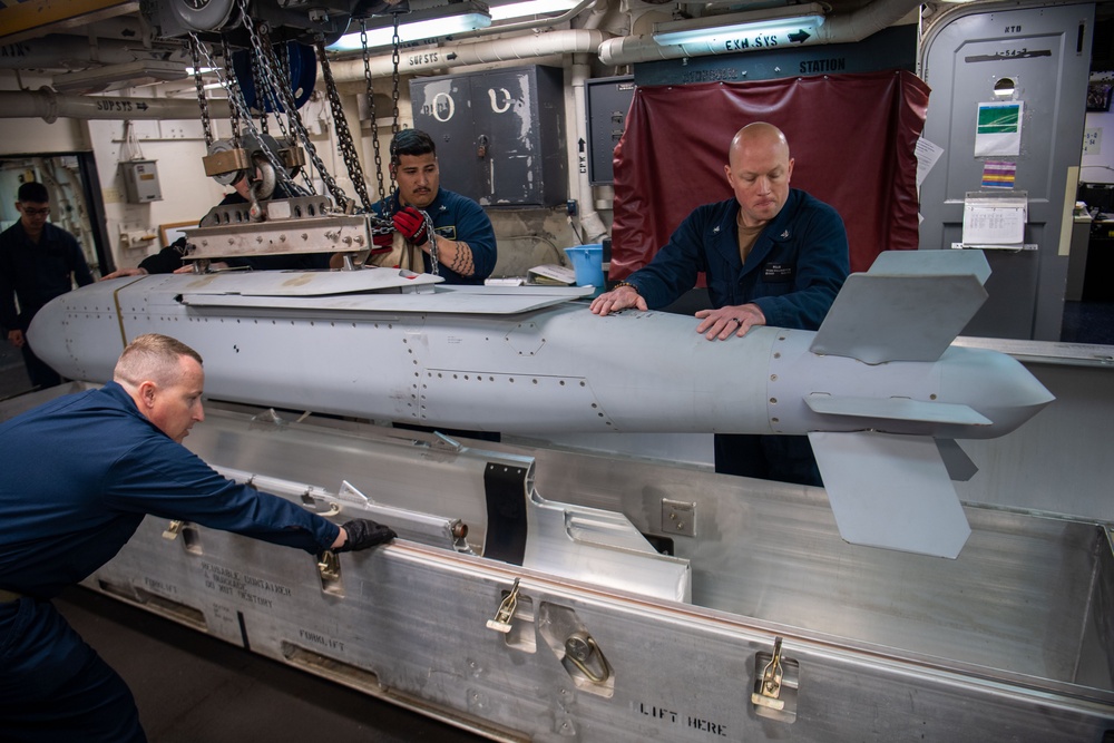 Sailors Move An Ordnance Shell