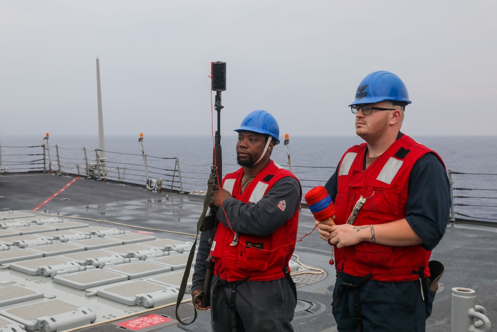 Sailors aboard the USS Howard conduct a replenishment-at-sea with the USNS Big Horn in the South China sea