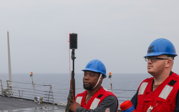Sailors aboard the USS Howard conduct a replenishment-at-sea with the USNS Big Horn in the South China sea