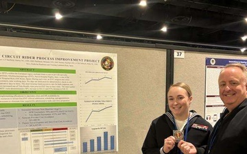 Hospital Corpsman 2nd Class Miranda Parkhurst receives coin from Rear Admiral Darin Via during the 2024 Association of Military Surgeons of the United States Conference