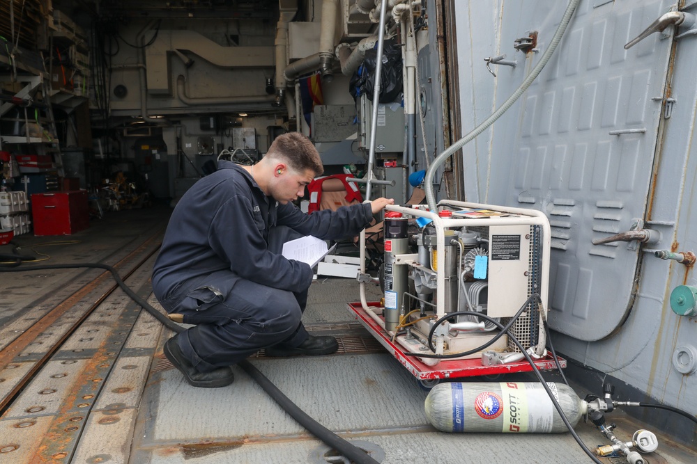 Sailors aboard the USS Howard test an emergency breathing air compressor in the South China Sea