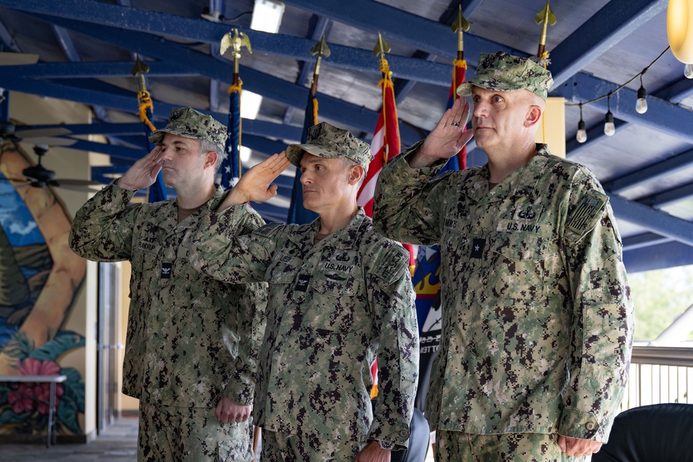 Left to right: Incoming and outgoing commanders of CTF 75 salute alongside the commander of Naval Expeditionary Combat Command.