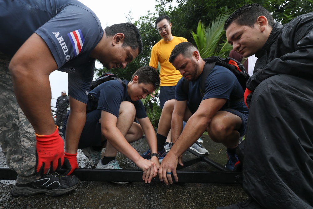Sailors and Costa Rican medical professionals work side-by-side to build medical tents at the pier