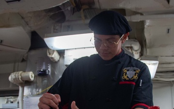 USS Ronald Reagan (CVN 76) Sailor prepares food
