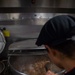 USS Ronald Reagan (CVN 76) Sailor prepares food