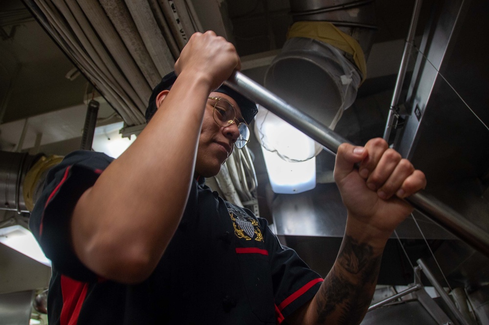 USS Ronald Reagan (CVN 76) Sailor prepares food