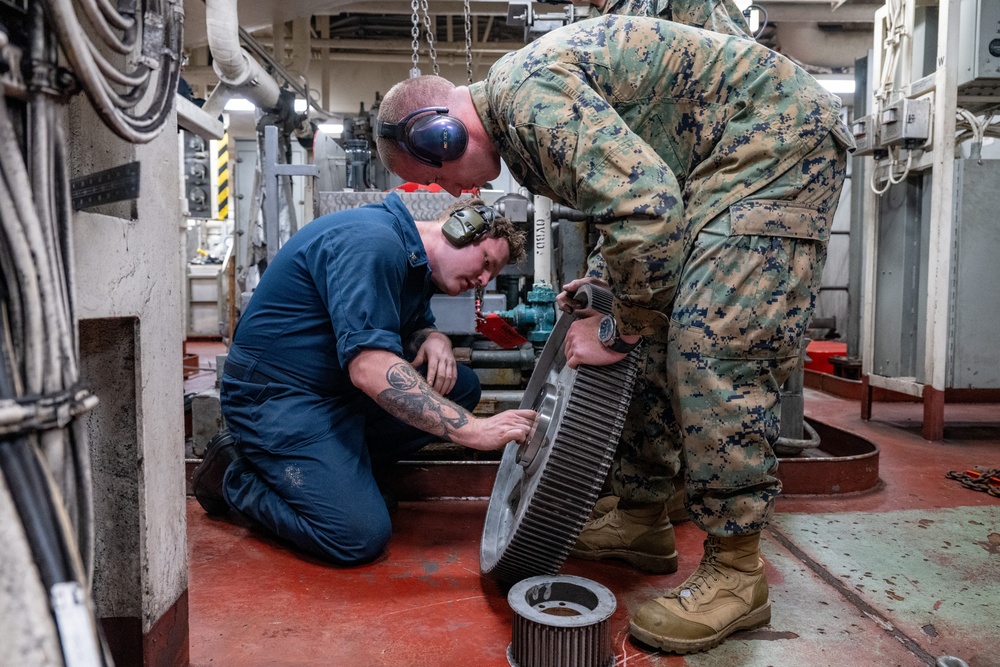 Sailor and Marine adjust final fitting of 3D printed component aboard USS Somerset