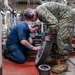 Sailor and Marine adjust final fitting of 3D printed component aboard USS Somerset