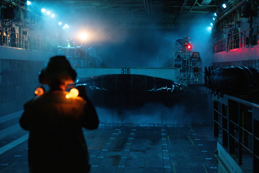 USS Somerset Boatswain’s Mate signals landing craft during night operations