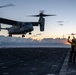 Airman signals to MV-22B Osprey during sunset