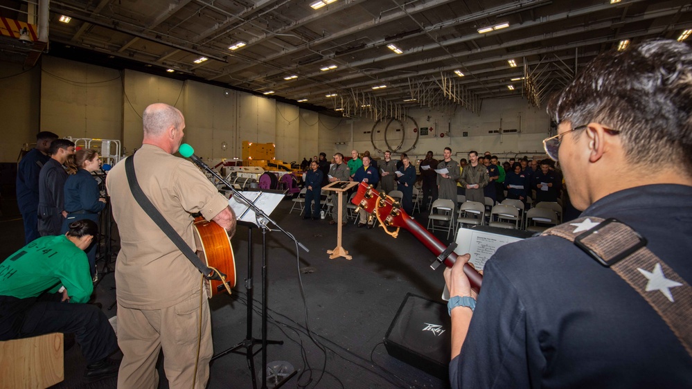 USS Ronald Reagan (CVN 76) Sailors hold a baptism in the Hangar Bay.