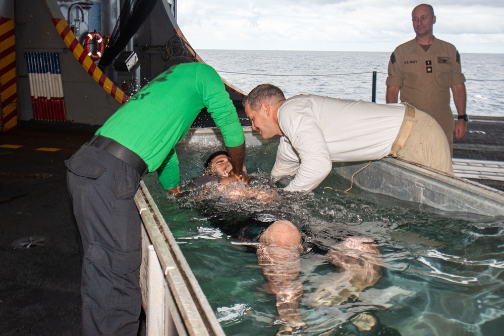 USS Ronald Reagan (CVN 76) Sailors hold a baptism in the Hangar Bay.