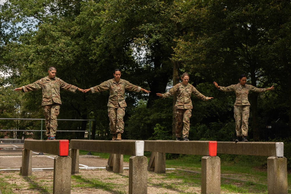 Service members negotiate a balance obstacle