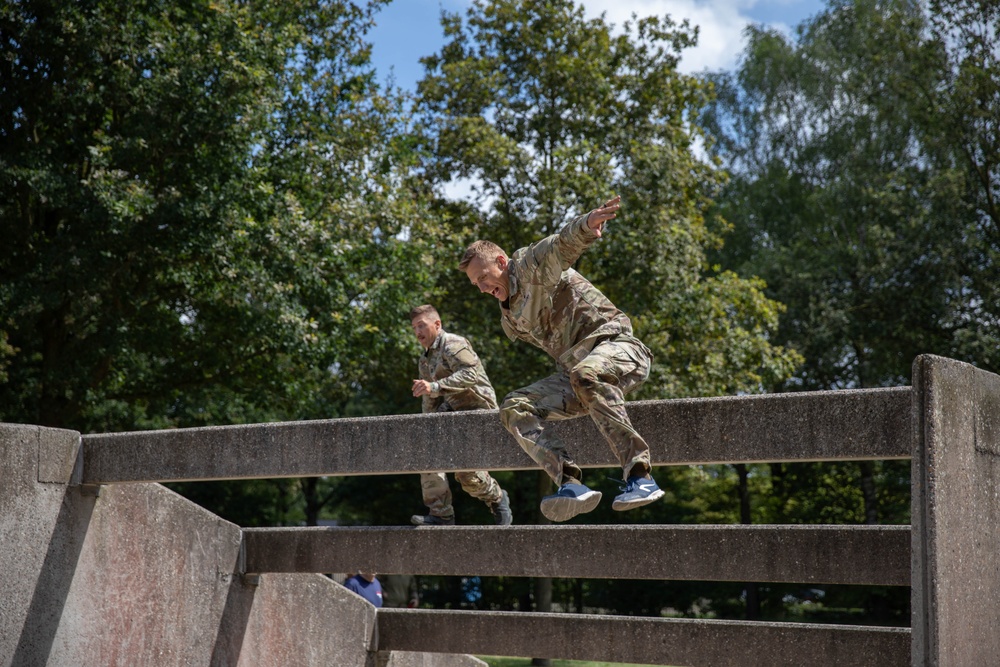 Two soldiers go over an obstacle