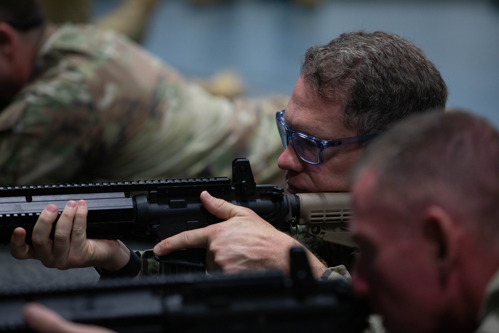 Col. Brent Dishman aims a simulated Colt C7NLD rifle