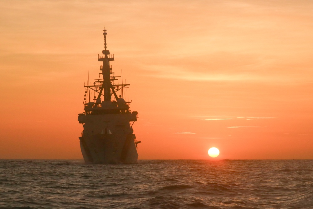 Coast Guard Cutter Stone steams at sunset in the Atlantic Ocean