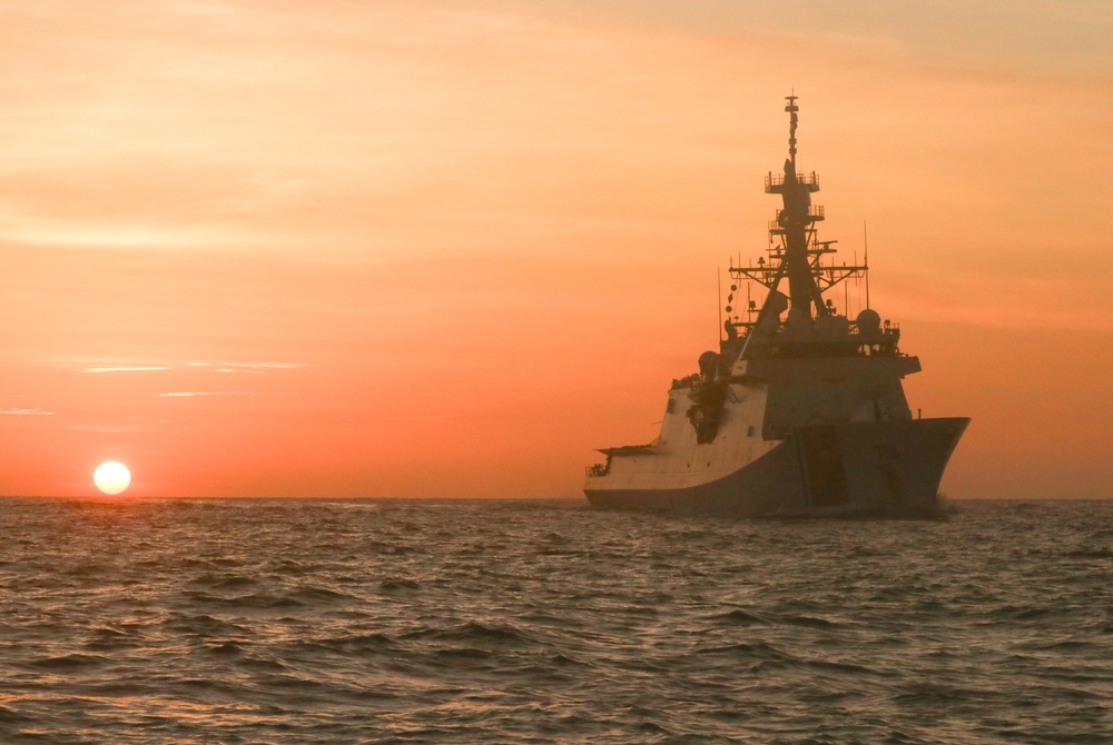 Coast Guard Cutter Stone steams at sunset in the Atlantic Ocean