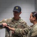 Sgt. 1st Class Kristoffer Friend instructs using a simulated weapon with 1st Lt. Brianna Mirmina