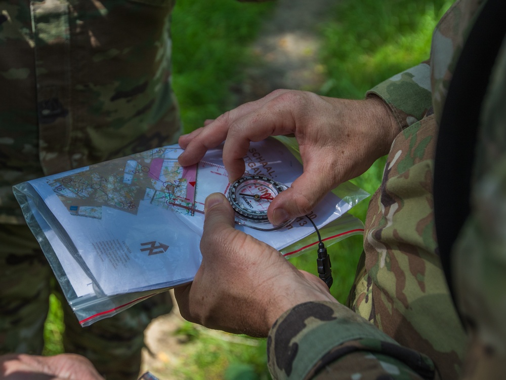 Service members representing team USA shoot an azimuth during a practice orienteering event