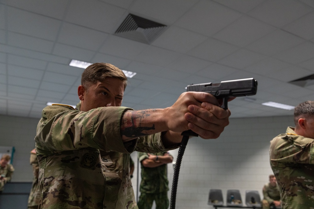 Sgt. 1st Class Benjamin Latham fires a Glock 17 simulation pistol