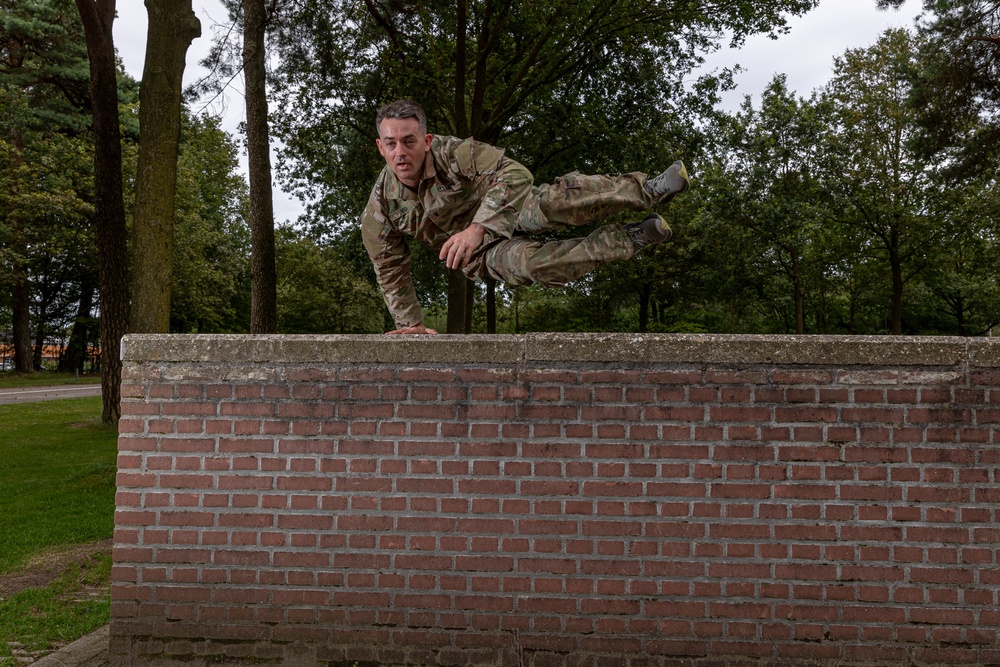 1st Lt.  Michael Vigh jumps over a wall