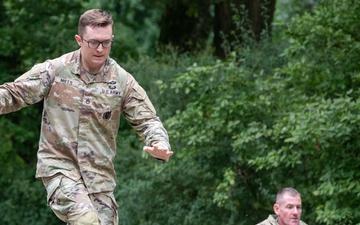soldiers run across beams on obstacle course
