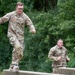 soldiers run across beams on obstacle course