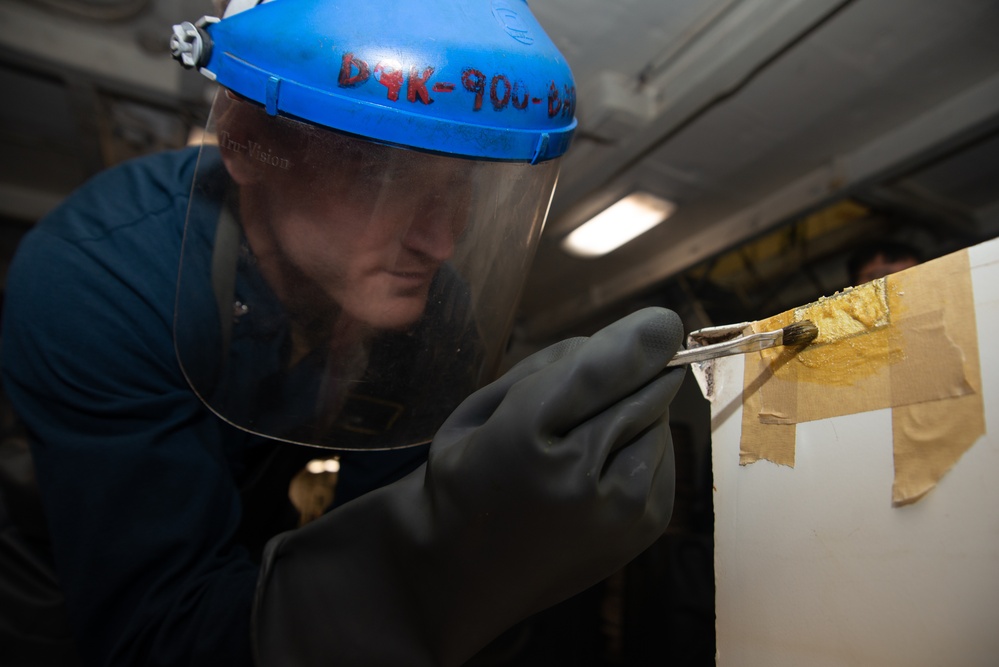 Nimitz Sailor Applies Paint Remover