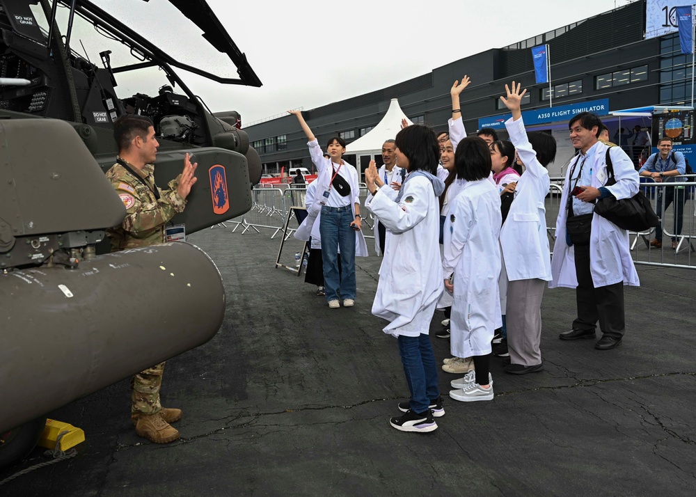 Military members talk with visiting rocketeer teams during FIA 2024