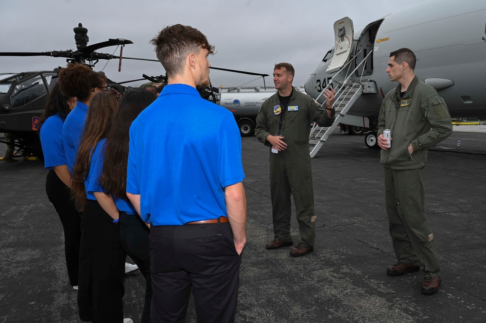 Military members talk with visiting rocketeer teams during FIA 2024