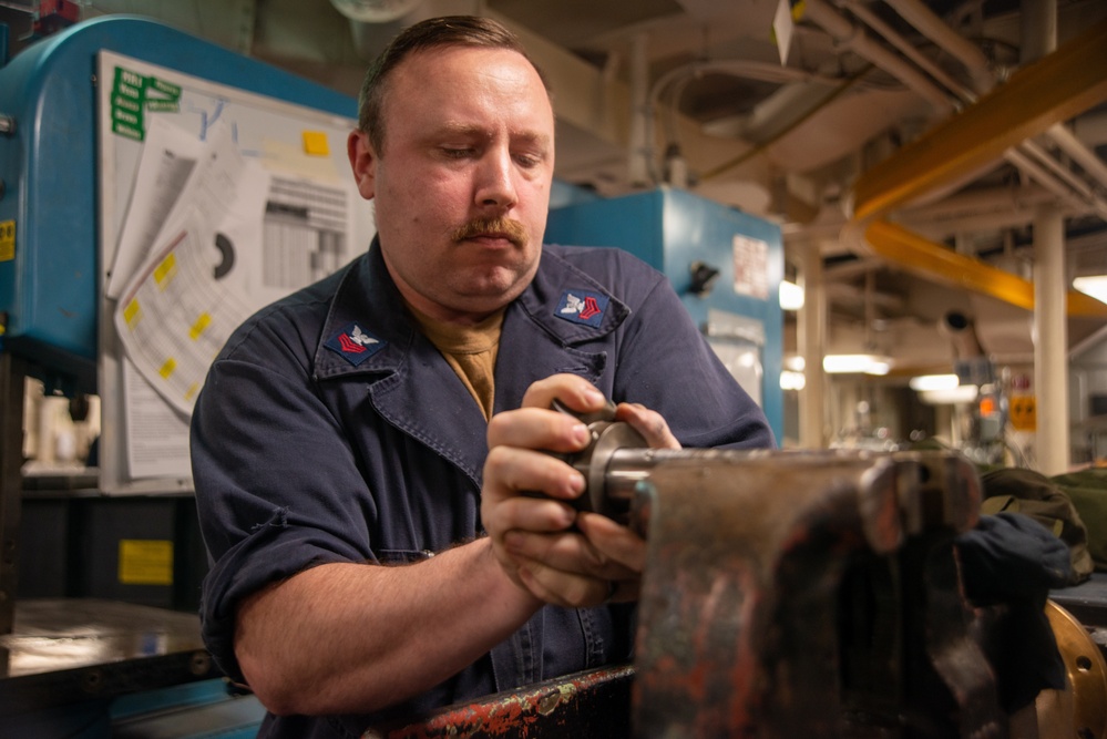 A Nimitz Sailor Attaches Gear To Stanchion Shaft