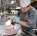 USS Spruance Sailor prepares food for dinner